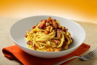 Spagetti carbonara ve çatalla peçeteye kase koy.
