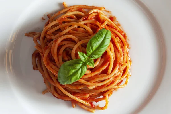 白い背景に隔離されたスパゲッティトマトとバジルとの皿のトップビューの詳細 — ストック写真
