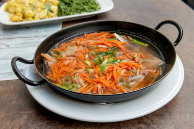 Sebzeli Viyana usulü sığır eti kaba bir masada servis edilir.