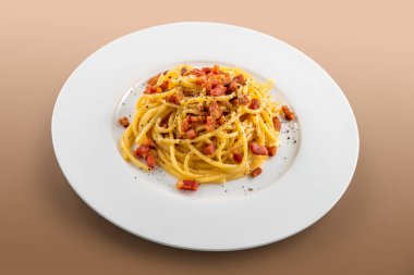 Kahverengi arka planda siyah biberli spagetti carbonara.