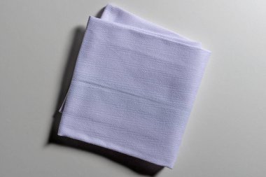 Gri arkaplanda izole edilmiş katlanmış açık mavi peçetenin üst görünümü