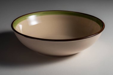 Beyaz arka planda izole edilmiş renkli kenarlı boş bir çorba kasesi.