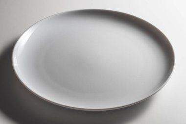 Kanatsız, boş, beyaz arka planda modern tasarımı olan, kıvrımlı kenarlı bir yemek tabağı.