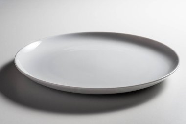 Kanatsız, boş, beyaz arka planda modern tasarımı olan, kıvrımlı kenarlı bir yemek tabağı.