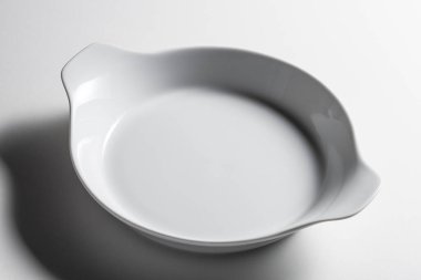 Beyaz arkaplanda izole edilmiş sapları olan beyaz seramik cocotte