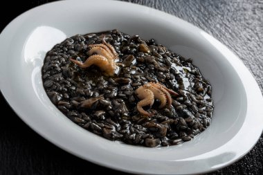 Siyah taşta mürekkep balığı mürekkebi olan risotto tabağı.