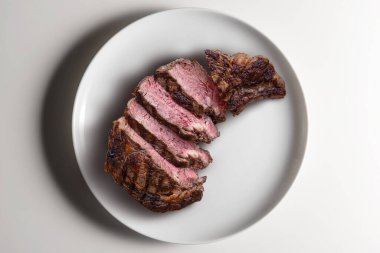 Beyaz arka planda izole edilmiş yuvarlak beyaz pirzola bifteğinin üst görüntüsü