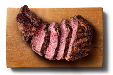 Dilimlenmiş kaburga etinin beyaz arka plandaki tahta kesme tahtasının üst görüntüsü