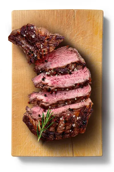 Top view of Flavored rib eye beef sliced on wooden cutting board in white background
