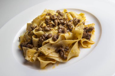 Beyaz arka planda yaban domuzu soslu pappardelle kaplama