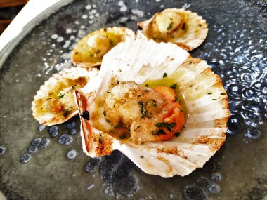 Midyeli aperatif yemeği ve siyah tabakta ızgara canestrelli.