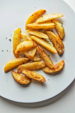 Beyaz arka planda aromalı patates kızartması tabağının üst görüntüsü