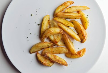 Beyaz arka planda aromalı patates kızartması tabağının üst görüntüsü