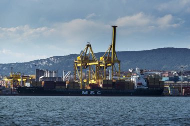 Trieste, İtalya - 7 Haziran 2023: Kargo gemileri Trieste Limanı yükleme iskelesine yanaştı: boşaltma konteynırları