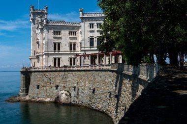 Trieste, İtalya - 7 Haziran 2023: Trieste Körfezi kıyısındaki kıyı yolundan Miramare Castle 'ın görüntüsü