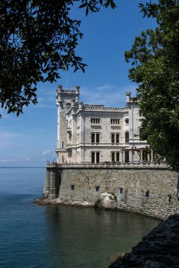 Trieste, İtalya - 7 Haziran 2023: Trieste Körfezi kıyısındaki kıyı yolundan Miramare Castle 'ın görüntüsü