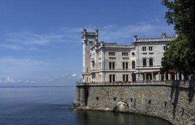 Trieste, İtalya - 7 Haziran 2023: Trieste Körfezi kıyısındaki kıyı yolundan Miramare Castle 'ın görüntüsü