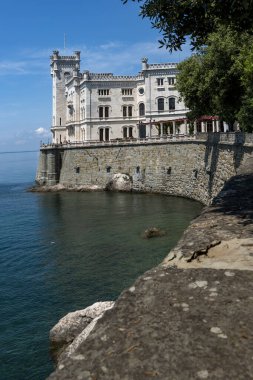 Trieste, İtalya - 7 Haziran 2023: Trieste Körfezi kıyısındaki kıyı yolundan Miramare Castle 'ın görüntüsü