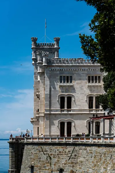 Trieste, İtalya - 7 Haziran 2023: Trieste Körfezi kıyısındaki kıyı yolundan Miramare Castle 'ın görüntüsü