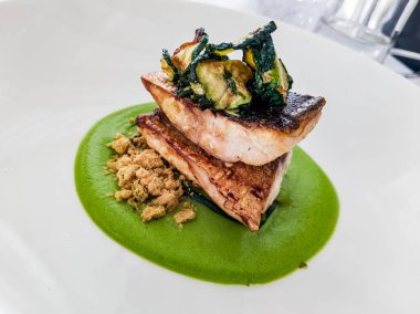 Kızarmış balık fileto, yeşil krema ve kabak.