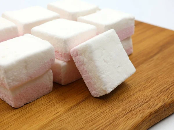 白色和粉红色的棉花糖堆在木板上 — 图库照片