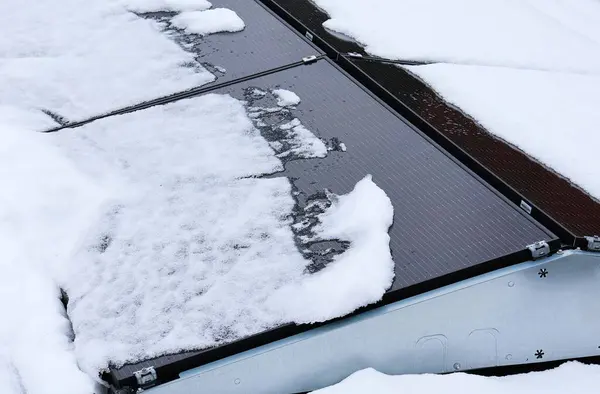 Snow on flat roof solar panels. Reduced to no solar energy due to snowfall.