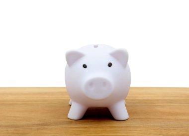  Domuz kumbarası, ahşap bir masanın önünde. Boşluğu kopyala.