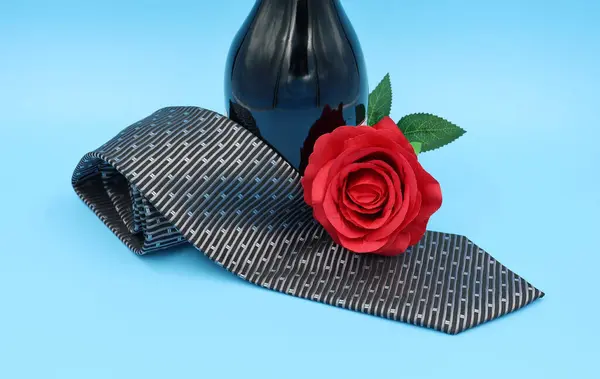  Mavi arka planda bir şişe şarap, kravat ve kırmızı gül. Anma Günü, düğün, Sevgililer Günü, aşk...