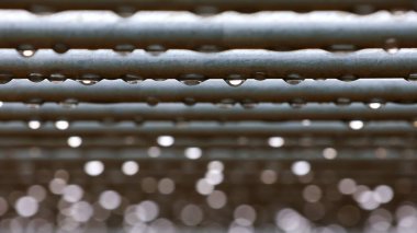  Yatay çubuklara yağmur damlaları. Seçici odaklanma. Su damlaları ve bokeh ile soyut arkaplan.