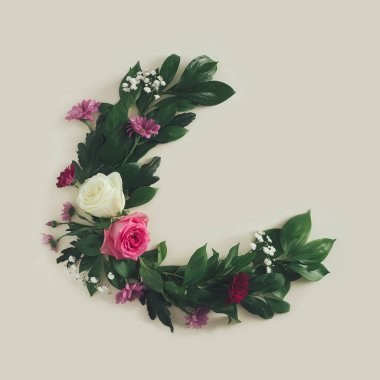 Taze pembe, beyaz güller ve kumlu pastel arka planda yeşil yapraklarla yapılmış yaz çiçekleri. Minimum yarım daire düz..