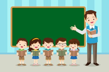 Mutlu Öğretmen Öğrencilere Sınıfta karatahtayla ders veriyor