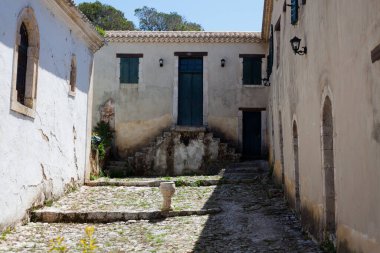 Küçük bir taş ve mavi gökyüzü ile eski dar bir dar sokağın güzel bir görüntüsü.