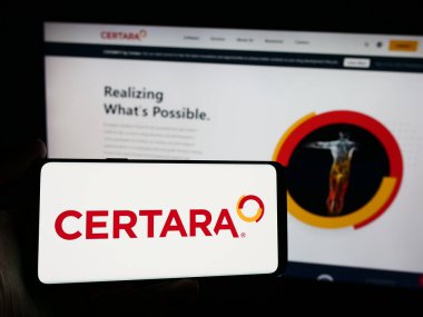 Stuttgart, Almanya - 04-18-2024: Amerikan biyoimülasyon şirketi Certara Inc. 'in logosunun bulunduğu cep telefonu sahibi kişi iş sayfasının önünde. Telefon ekranına odaklan.