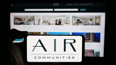 Stuttgart, Almanya - 04-26-2024: İş sayfası önünde Apartman Gelir Kurumu (AIR Communities) logosu olan cep telefonu sahibi kişi. Telefon ekranına odaklan.