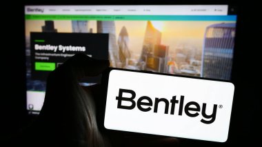 Stuttgart, Almanya - 04-26-2024: Amerikan yazılım şirketi Bentley Systems Inc. 'in logosu olan cep telefonu sahibi kişi iş sayfasının önünde. Telefon ekranına odaklan.