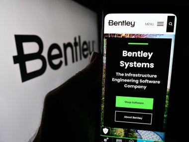 Stuttgart, Almanya - 04-26-2024: ABD 'li yazılım şirketi Bentley Systems Inc.' in web sitesi ile iş logosu önünde cep telefonu tutan kişi. Telefon ekranının merkezine odaklan.