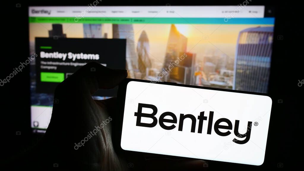 Stuttgart, Germany - 04-26-2024: Person holding mobile phone with logo of American software company Bentley Systems Inc. in front of business web page. Focus on phone display.