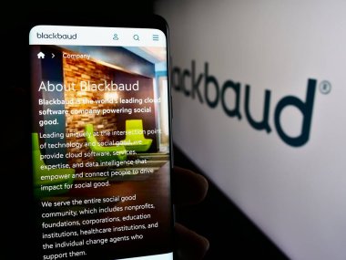 Stuttgart, Almanya - 04-28-2024: İş logosu önünde ABD 'li yazılım şirketi Blackbaud Inc.' in web sayfası ile akıllı telefon tutan kişi. Telefon ekranının merkezine odaklan.