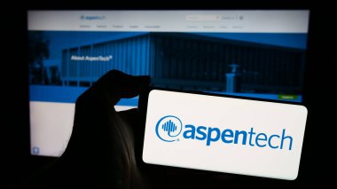 Stuttgart, Almanya - 04-28-2024: ABD 'li yazılım şirketi Aspen Technology Inc. (AspenTech)' in logosunun bulunduğu akıllı telefon sahibi kişi. Telefon ekranına odaklan.