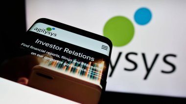 Stuttgart, Almanya - 04-28-2024: İş logosu önünde ABD 'li yazılım şirketi Agilysys Inc.' in web sitesi ile cep telefonu. Telefon ekranının sol üst kısmına odaklan.
