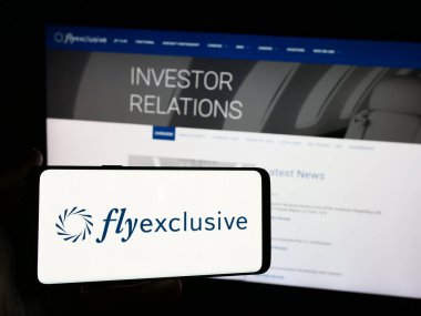 Stuttgart, Almanya - 04-29-2024: Amerikan özel jet şirketinin logosunun bulunduğu cep telefonu sahibi şahıs özel jet şirketi ExlyExc. Telefon ekranına odaklan.