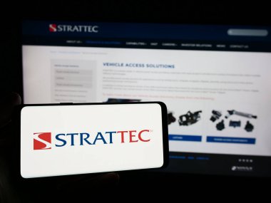 Stuttgart, Almanya - 05-02-2024: İnternet sitesi önünde ABD 'li otomotiv şirketi Strattec Security Corporation' ın logosuna sahip kişi. Telefon ekranına odaklan.