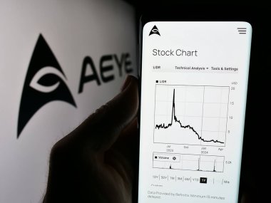 Stuttgart, Almanya - 05-02-2024: İş logosu önünde ABD 'li lidar yazılım şirketi AEye Inc.' in web sitesi ile cep telefonu tutan kişi. Telefon ekranının merkezine odaklan.