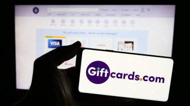 Stuttgart, Almanya - 05-02-2024: İnternet sitesi önünde ABD 'li hediye kartı perakende şirketi Giftcards.com LLLC' nin logosuna sahip kişi. Telefon ekranına odaklan.