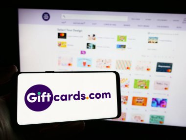 Stuttgart, Almanya - 05-02-2024: Üzerinde Amerikan hediye kartı perakende şirketi Giftcards.com LLLC 'nin logosu bulunan cep telefonu sahibi kişi web sayfası önünde. Telefon ekranına odaklan.