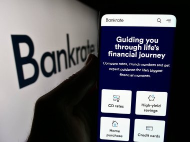 Stuttgart, Almanya - 05-03-2024: İş logosu önünde ABD 'li tüketici finans şirketi Bankrate LLC' nin web sayfası ile cep telefonu tutan kişi. Telefon ekranının merkezine odaklan.