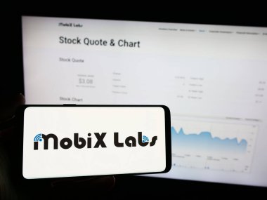 Stuttgart, Almanya - 05-03-2024: İnternet sayfasının önünde Amerikan efsanevi yarı iletken şirketi Mobix Labs Inc. 'in logosu olan cep telefonu sahibi kişi. Telefon ekranına odaklan.