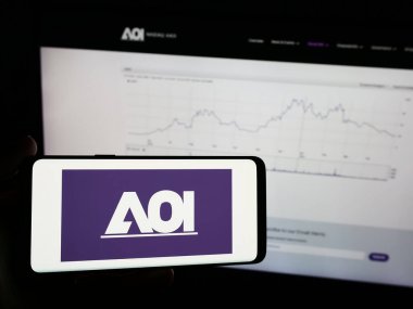 Stuttgart, Germany - 05-03-2024: Person holding mobile phone with logo of American company Applied Optoelectronics Inc. (AOI) in front of web page. Focus on phone display. clipart