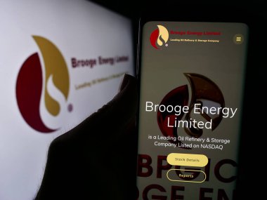 Stuttgart, Almanya - 05-06-2024: Emirati petrol şirketi Brooge Energy Limited 'in internet sayfası ile logo önünde cep telefonu tutan kişi. Telefon ekranının merkezine odaklan.