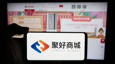 Stuttgart, Germany - 05-06-2024: Person holding cellphone with logo of Chinese e-commerce company Jowell Global Ltd. in front of business webpage. Focus on phone display. clipart